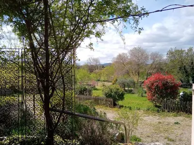 a view of a garden from behind a fence at Villa couleurs du sud in Bize-Minervois
