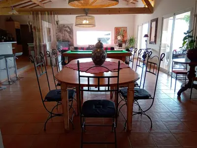 a table and chairs with a vase on top of it at Villa couleurs du sud in Bize-Minervois