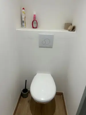 a white toilet in a room with a shelf at Les berges de la cité in Carcassonne
