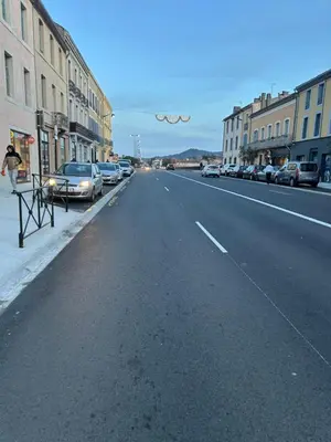 an empty city street with parked cars and buildings at Les berges de la cité in Carcassonne