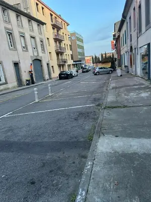 an empty city street with cars parked on the road at Les berges de la cité in Carcassonne
