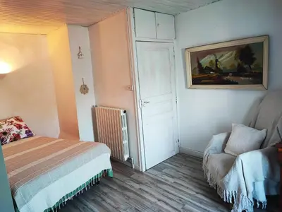 a small bedroom with a bed and a chair at Chez Christine et Fred in Villedaigne