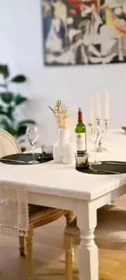 a white table with glasses and a bottle of wine on it at Grand appartement centre historique in Narbonne