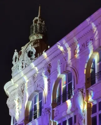 a building is lit up in purple at night at Grand appartement centre historique in Narbonne