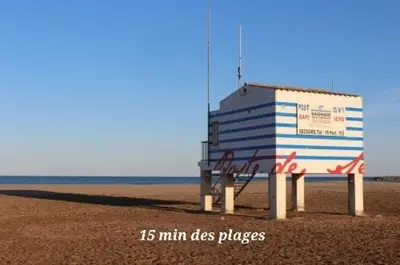 a building on a beach with the ocean in the background at Grand appartement centre historique in Narbonne