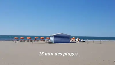 a beach with umbrellas and a building on the beach at Grand appartement centre historique in Narbonne