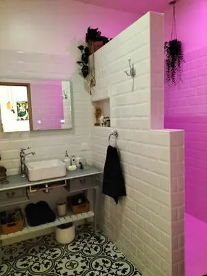 a bathroom with pink lights in a room at Grand appartement centre historique in Narbonne