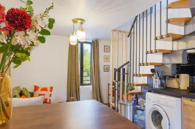 a kitchen with a table with a vase of flowers at T2 cosy tout équipé, parking et wifi gratuit, Castres in Castres