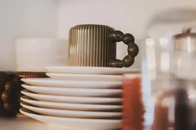 a stack of white plates sitting on a table at T2 cosy tout équipé, parking et wifi gratuit, Castres in Castres