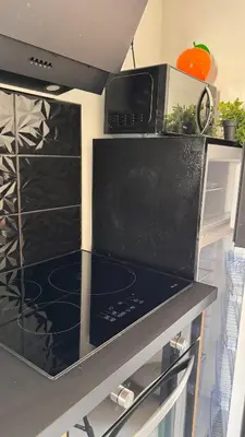 a microwave oven sitting on top of a kitchen counter at T2 cosy tout équipé, parking et wifi gratuit, Castres in Castres
