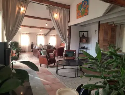 a living room with a couch and a table at La Colline aux Oiseaux - Quatre chambres in Fa