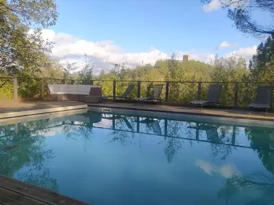 a swimming pool with two chairs on a fence at La Colline aux Oiseaux - Quatre chambres in Fa