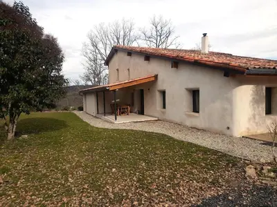 a white building with a table in front of it at La Colline aux Oiseaux - Quatre chambres in Fa