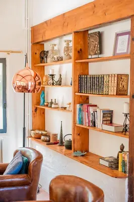 a living room with wooden shelves with books at La Colline aux Oiseaux - Quatre chambres in Fa
