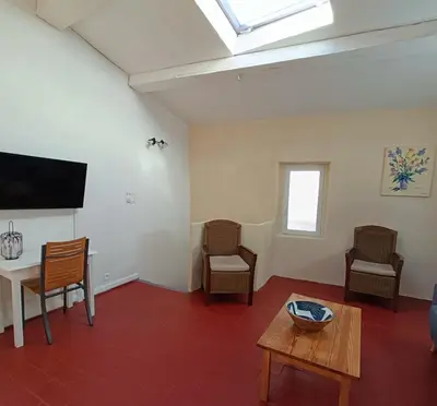 a kitchen and dining room with a table and a refrigerator at la guitoune du pélican halte à vélo in Puisserguier