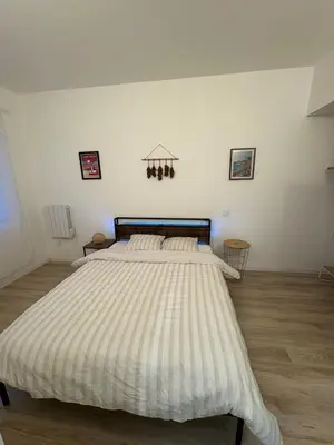 a bedroom with a large bed with a striped comforter at Comme à la maison in Carcassonne