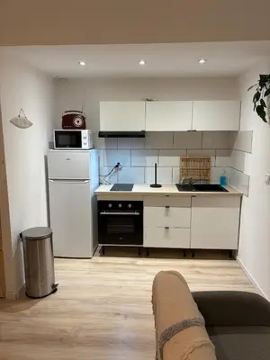 a kitchen with white cabinets and a stove top oven at Comme à la maison in Carcassonne