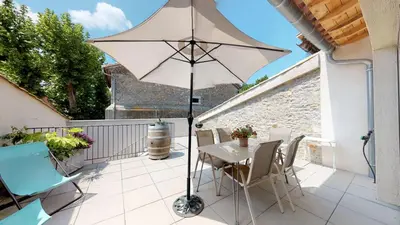 a patio with a table and an umbrella at Domaine Paul Huc in Fabrezan