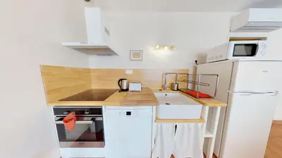 a small kitchen with white appliances and a white refrigerator at Domaine Paul Huc in Fabrezan