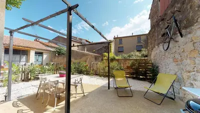 a patio with a table and chairs and a building at Domaine Paul Huc in Fabrezan