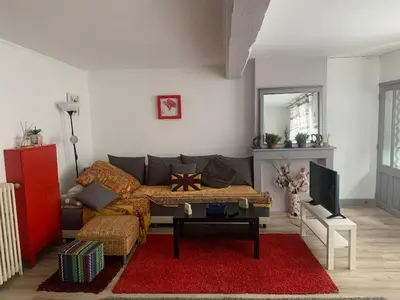 a living room with a couch and a red rug at appartement T3 duplex centre de Castelnaudary in Castelnaudary