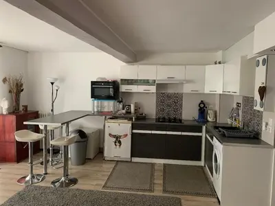 a kitchen with white cabinets and a table in it at appartement T3 duplex centre de Castelnaudary in Castelnaudary