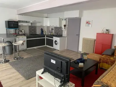 a living room with a kitchen and a tv in it at appartement T3 duplex centre de Castelnaudary in Castelnaudary