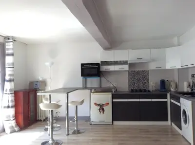 a kitchen with a table and some chairs in it at appartement T3 duplex centre de Castelnaudary in Castelnaudary