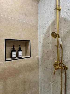 a bathroom with a shower with two bottles of soap at La Table du Chevalier - Cité in Carcassonne