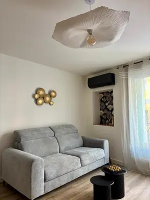 a living room with a couch and a ceiling fan at La Table du Chevalier - Cité in Carcassonne