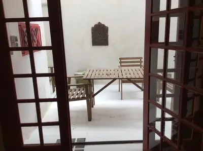 a room with a table and a bench through a door at grand studio avec terrasse centre Castelnaudary in Castelnaudary
