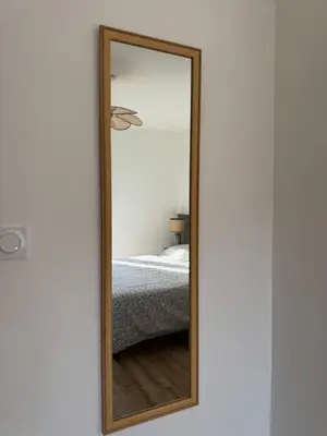a mirror with a wooden frame in a bedroom at Le Petit Faubourg - Cocooning and bright - Cité in Carcassonne
