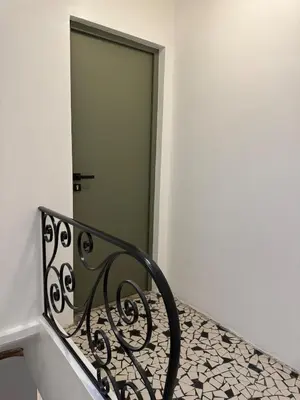 a staircase with a wrought iron railing and a door at Le Petit Faubourg - Cocooning and bright - Cité in Carcassonne