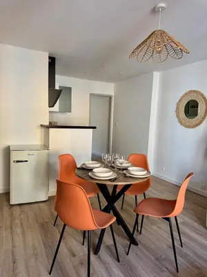 a dining room with a table and orange chairs at Le Petit Faubourg - Cocooning and bright - Cité in Carcassonne