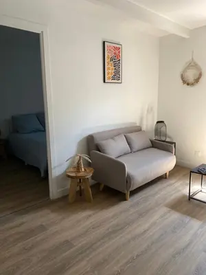 a kitchen with a small table and a refrigerator at Charmant T2 cosy à Mazamet in Mazamet