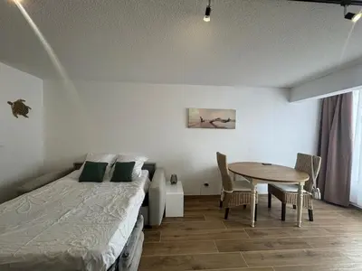 a bedroom with a bed and a table with chairs at Vacances à Gruissan in Gruissan