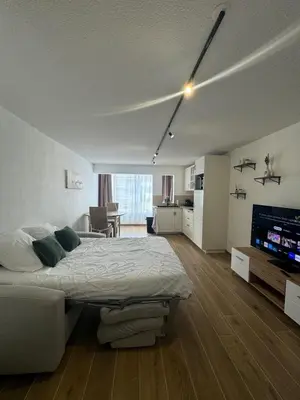 a bedroom with a large bed and a living room at Vacances à Gruissan in Gruissan