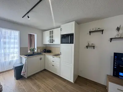 a kitchen with white cabinets and a sink at Vacances à Gruissan in Gruissan