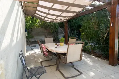 a table and chairs on a patio under a pergola at La Maison de Jack in Raissac-dʼAude