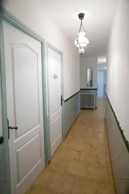 a hallway with a white door and a tile floor at La Maison de Jack in Raissac-dʼAude