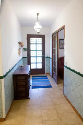 a hallway with a door leading to a bathroom with blue mats at La Maison de Jack in Raissac-dʼAude