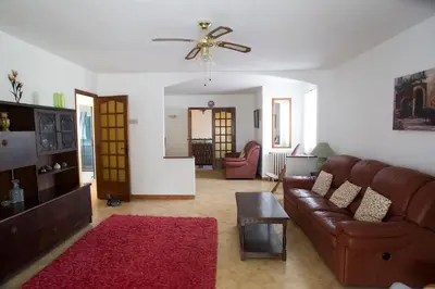 a living room with a couch and a ceiling fan at La Maison de Jack in Raissac-dʼAude