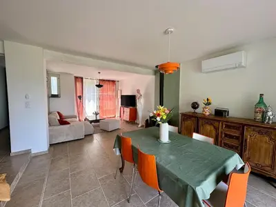 a living room with a green table and chairs at Maison tout confort proche centre avec jardin in Carcassonne