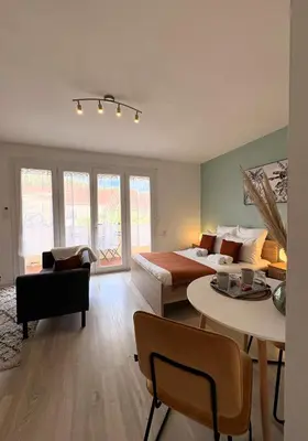 a bedroom with a bed and a living room at L'appartement Rome Antique - Climatisation - Terrasse in Narbonne