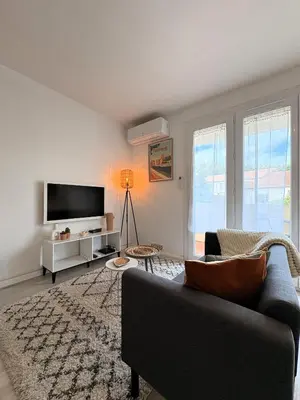 a living room with a couch and a tv at L'appartement Rome Antique - Climatisation - Terrasse in Narbonne