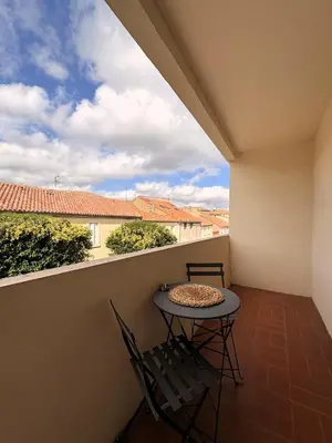 a balcony with a table and chairs on a balcony at L'appartement Rome Antique - Climatisation - Terrasse in Narbonne