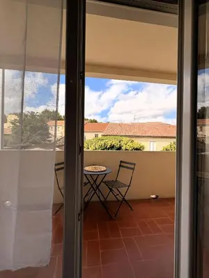 a view from the sliding glass door of a patio with a table at L'appartement Rome Antique - Climatisation - Terrasse in Narbonne