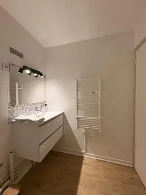 a white bathroom with a sink and a mirror at L'appartement Rome Antique - Climatisation - Terrasse in Narbonne