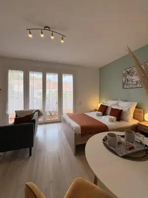 a bedroom with a bed and a living room at L'appartement Rome Antique - Climatisation - Terrasse in Narbonne