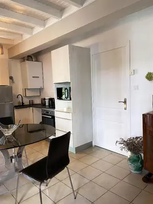 a kitchen with a table and chairs in a room at Le jardin du Griffoul in Nébias